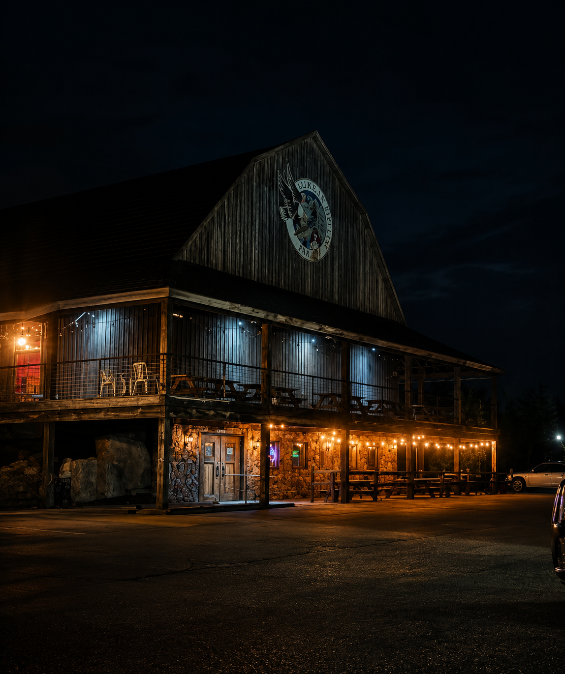 The Pipeline Underground Saloon barn building at night with porch lights and dark sky